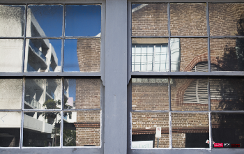 Glass windows reflecting a brick building